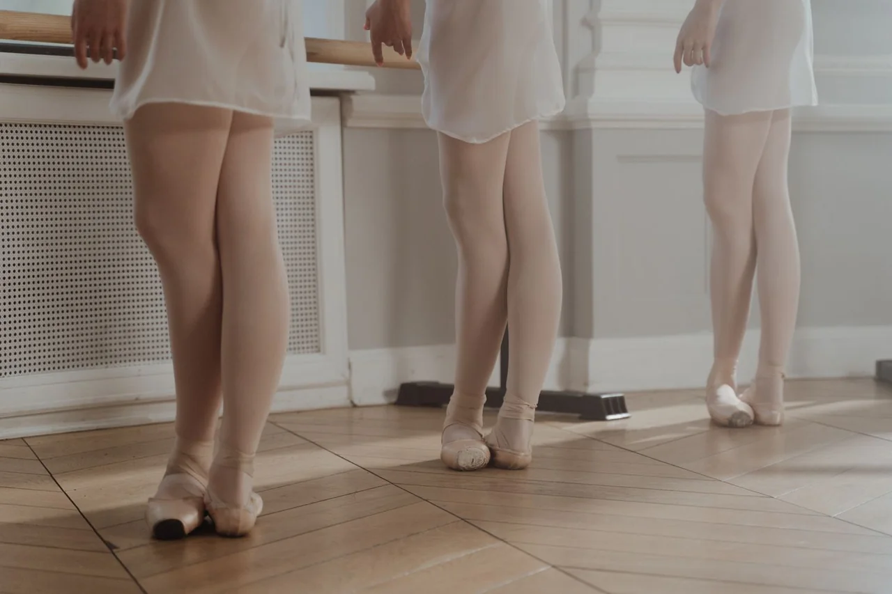 Ballet students rehearsing classical positions at the barre