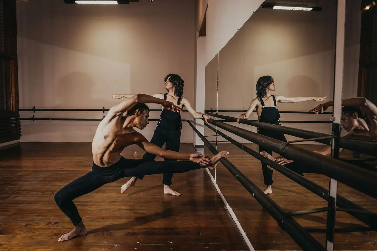Two dancers executing synchronized movement during partner work