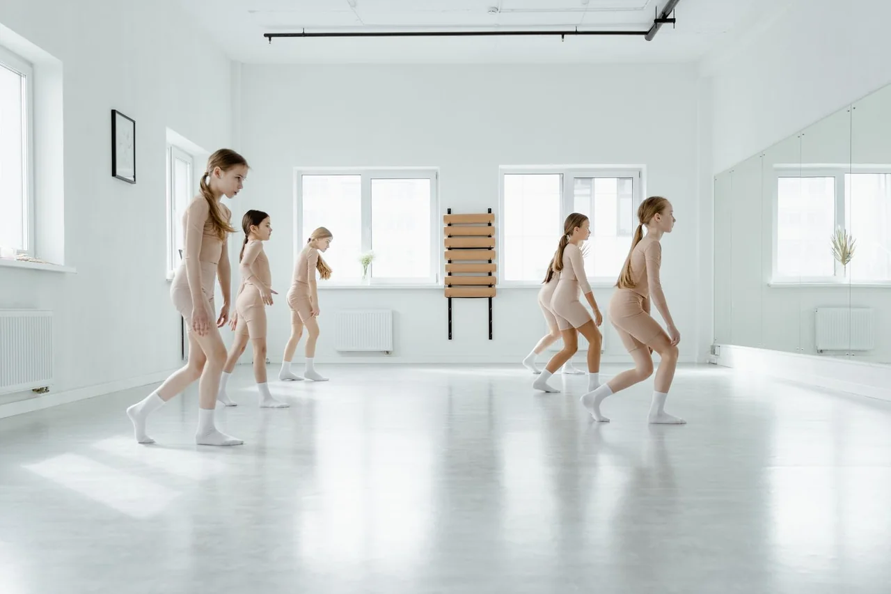 Generous windows bringing soft daylight into the wooden studio rehearsal space