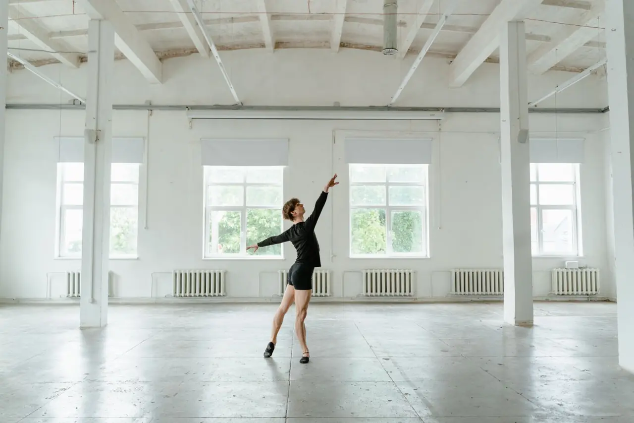 Contemporary dancer exploring dynamic shape in studio lighting