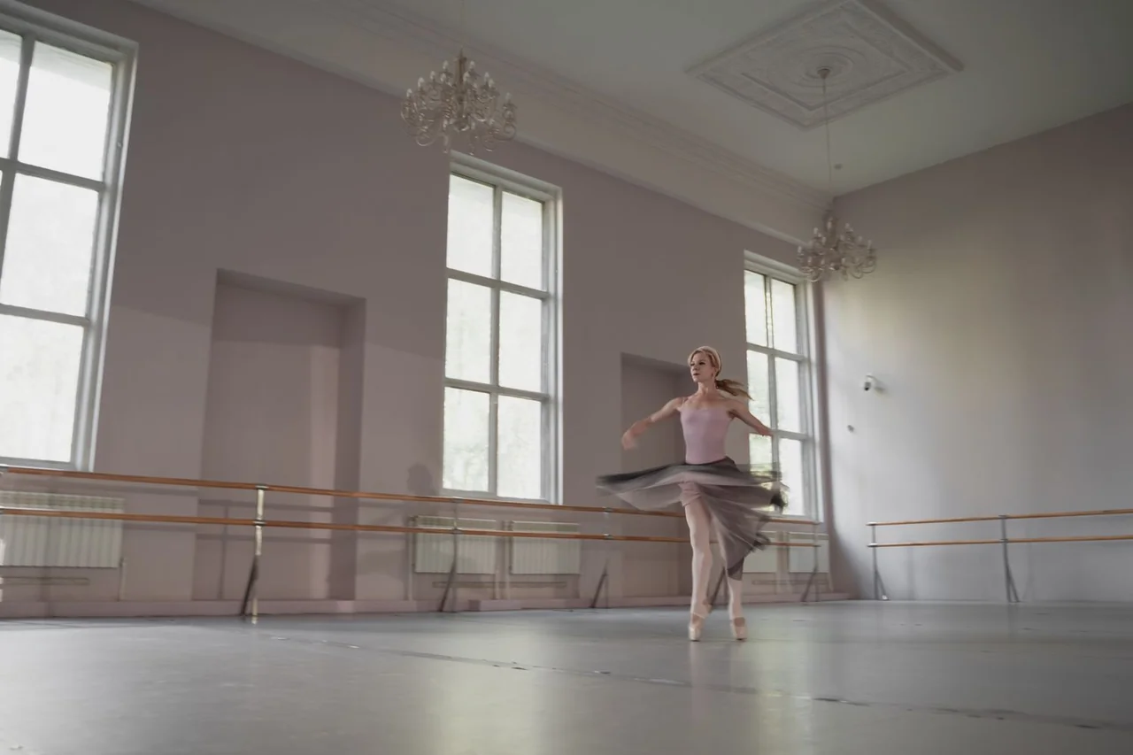 Ballerina practicing a graceful sequence in the bright sunlit dance studio at Lumari Quessa Vela in Trois-Rivieres