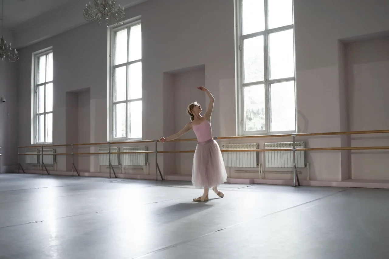 Studio rehearsal interior with wooden floor, mirrors and soft ambient daylight